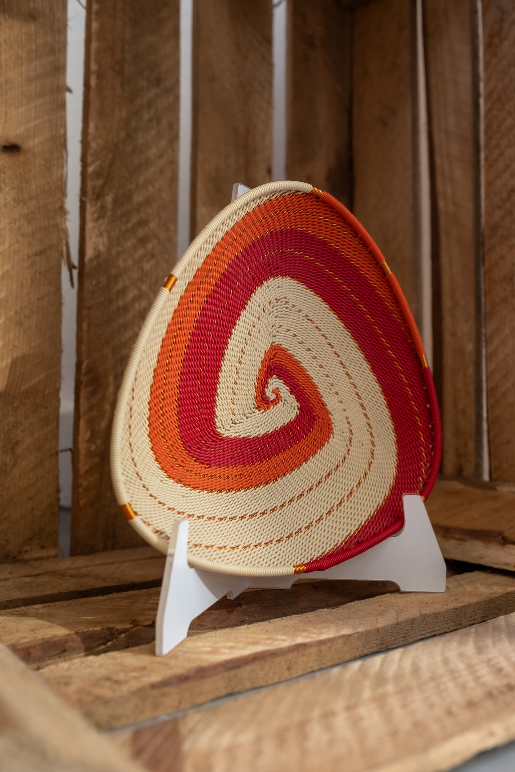 a white, red and orange telephones wire handmade bowl
